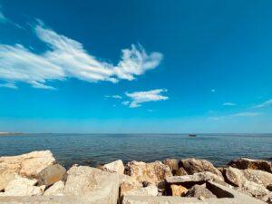 brown rocks near body of water under blue sky during daytime