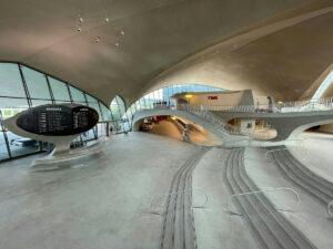 Interior view of the TWA Flight Center featuring curved architecture and a departures board.